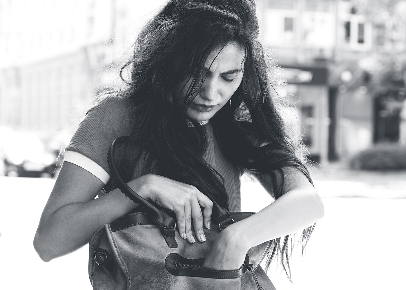 Caucasian female looking down with hands in her purse