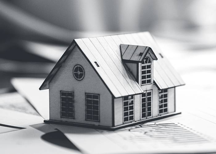 Tiny house sitting on a table with paperwork underneath