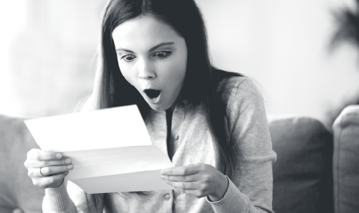 Surprised woman looking at paper statement