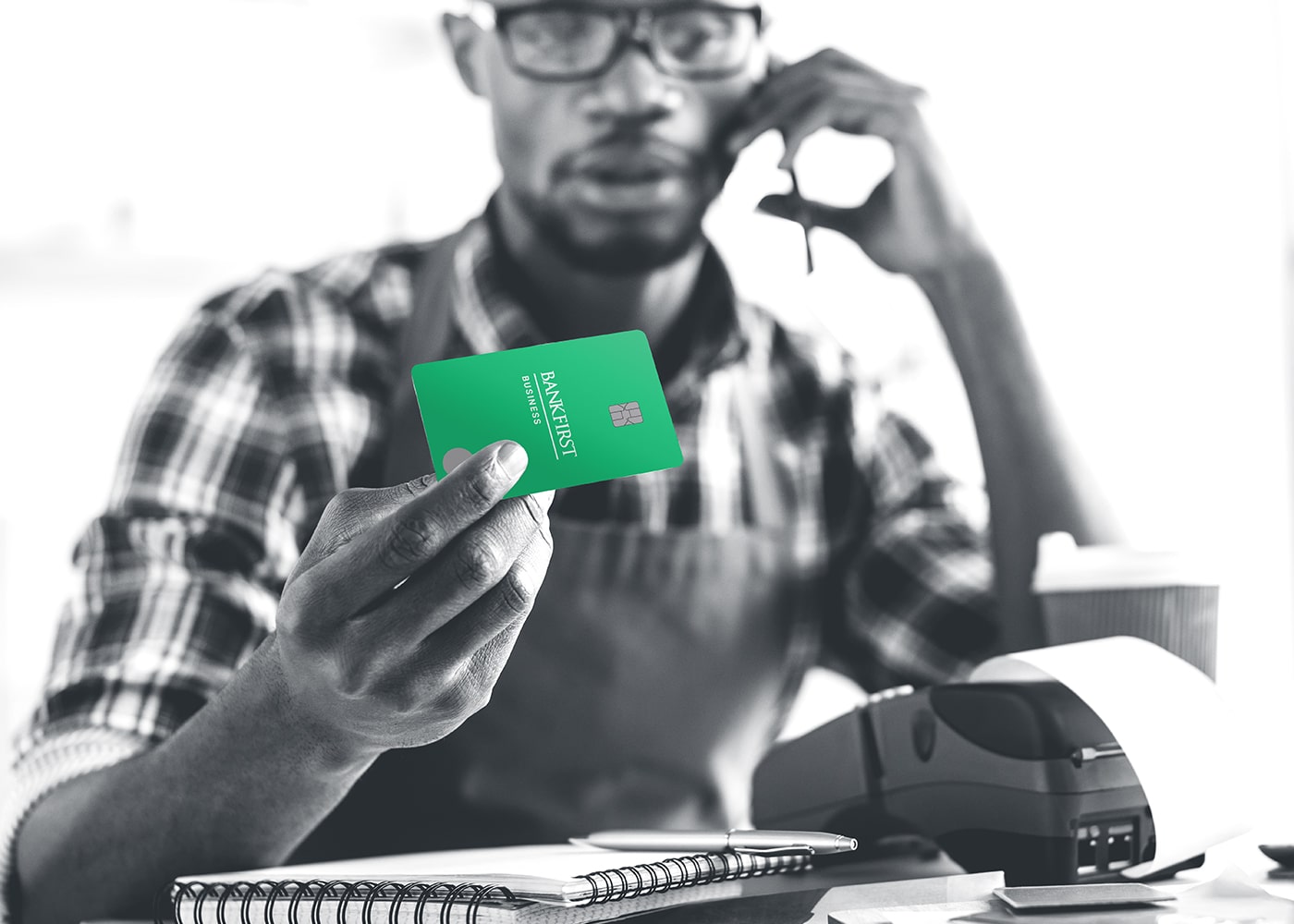 African American man holding a green BankFirst business debit card