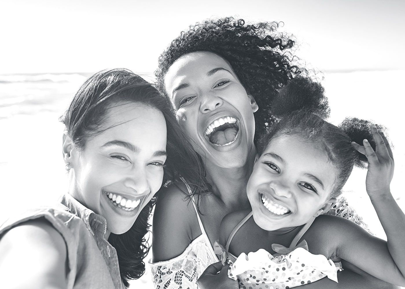 Three African American females smiling on the beach