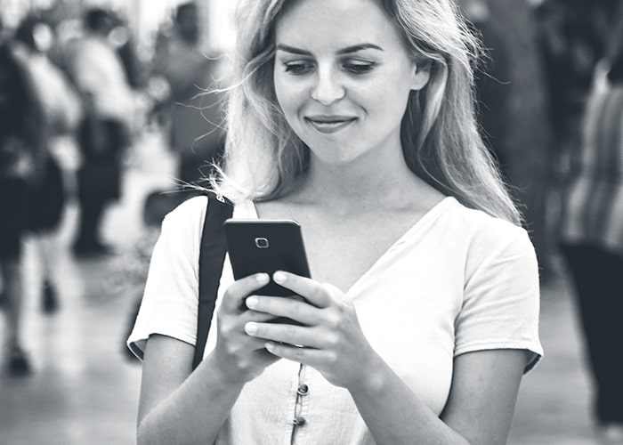 Woman in crowd looking at her cell phone