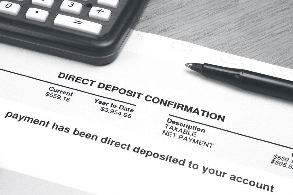 Direct Deposit Confirmation paperwork with pen and calculator nearby