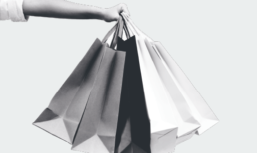 Hand holding out multiple shopping bags