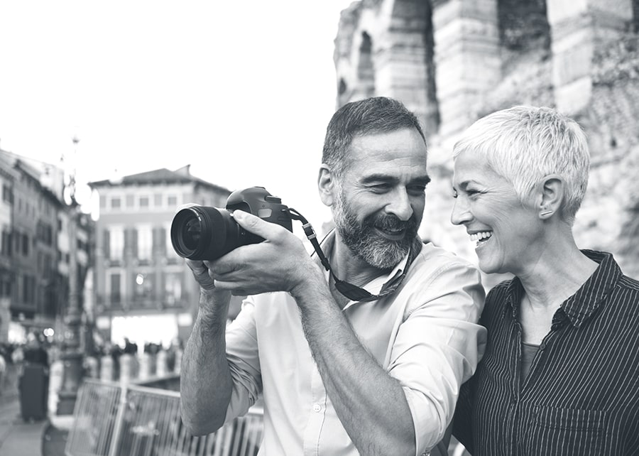 Smiling man and woman looking at each other while the man holds up a camera